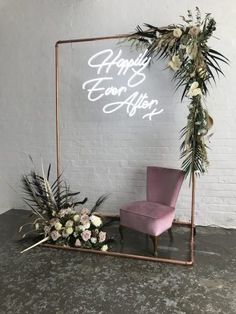 a chair sitting in front of a mirror with flowers and greenery on it that says happy new year