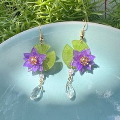 Immerse yourself in the enchanting world of Japanese aesthetics with these Purple Water Lily Lotus Flower with Crystal Drops Japanese Earrings. Handcrafted with utmost care and attention to detail, these earrings are a delightful blend of elegance, charm, and kawaii aesthetics. The centerpiece of these handmade earrings is the exquisite purple water lily lotus flower. Inspired by the beauty of water lily pond, the intricate detailing of the petals captures the essence of grace and tranquility. T Lily Pad Earrings, Water Lily Earrings, Water Lily Jewelry, Purple Water Lily, Japanese Earrings, Purple Water, Earrings Kawaii, Aesthetic Earrings, Lily Lotus