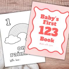 baby's first 123 book with love and rainbow on it, next to an adult coloring book