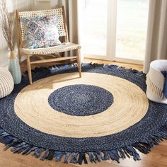 a blue and white rug with fringes on it in front of a wooden chair