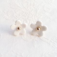 Cannot decide which pair of earrings you are going to wear today? Our everyday daisy stud earrings can always be your answer. The blooming daisy flowers with their simple but pretty design can easily go well with your jeans or dresses, ready for different occasion. Handmade porcelain daisy flowers; Gold-filled beads; Gold-plated sterling silver ear posts and backs. Gold- or silver-plated colour will fade over time. This is a normal result from long-term wear and contact with air. However, with c Minimalist Everyday Flower Charm Earrings, Delicate White Earrings For Everyday Wear, Delicate Everyday Flower-shaped Earrings, Delicate Flower-shaped Earrings For Everyday, White Daisy-shaped Everyday Jewelry, White Flower Charm Earrings For Everyday, White Daisy Jewelry For Everyday, Everyday White Daisy Shaped Jewelry, Everyday White Flower Jewelry