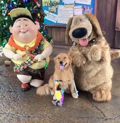 there are two dogs and a man next to a christmas tree with decorations on it