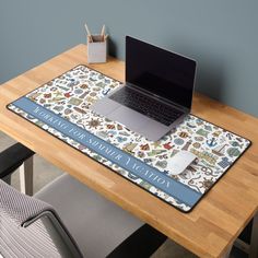 a laptop computer sitting on top of a wooden desk next to a mouse and keyboard