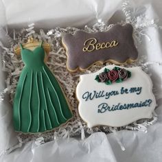 two decorated cookies in a box with the words will you be my bridesmaid?