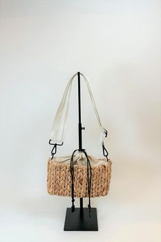 Because of your enormous love of The Fullerton and St. Augustine bags, we added a 3rd bag to this straw family. Introducing the smallest version of this collection we call the Hamptons. Inspired by all the mini bag trends and designed with all our signature straw materials and details. Drawcord top to hold your belongings in place, finished with an adjustable white nylon and leather strap make this bag a fun and easy choice for a sunscreen, phone and keys kinda day. *color may vary slightly by b Trendy Beige Braided Bag, Trendy Braided Beige Bag, Trendy Braided Straw Bag For Travel, Summer Straw Crossbody Bag, Vacation Crossbody Straw Bag With Braided Handles, Vacation Braided Handles Crossbody Straw Bag, Vacation Straw Crossbody Bag With Braided Handles, Trendy Natural Braided Shoulder Bag, Chic Beige Braided Bag