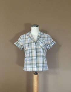 Authentic vintage short sleeve shirt. Has collar with full button up front. Dates from late 80's to early 90's. Classic plaid design. Soft cotton blend. Shorter cropped style. This shirt is in great condition with little to average signs of previous use. Still has many years of wear left. Check out my shop 'TheBarnLadder' for reviews and feedback All items are free of rips, tears, holes, and stains. Vintage items are subject to signs of previous wear. Purchase Policy All vintage items are non re Cheap Vintage Cotton Shirt, Plaid Short Sleeve Camp Shirt With Relaxed Fit, Retro Plaid Short Sleeve Blouse, Retro Plaid Short Sleeve Tops, Retro Plaid Short Sleeve Shirt, Retro Short Sleeve Plaid Blouse, Retro Short Sleeve Plaid Shirt, Retro Short Sleeve Plaid Tops, 90s Short Sleeve Tops With Button Closure