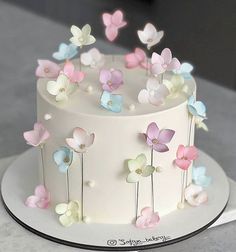 there is a white cake with flowers on the top and bottom, decorated in pastel colors