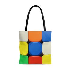 a multicolored tote bag with black handles and two different colored blocks on the front