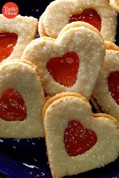 heart shaped cookies with jelly filling on a blue plate