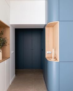 an empty hallway with blue walls and wooden shelves