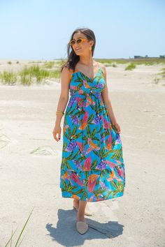 Get ready for your next summer vacay with our Blue Lagoon Dress! This midi dress features a beautiful tropical print in vibrant hues, complete with tropical leaf and bird motifs. The sweetheart neckline adds a flirty touch, while the adjustable spaghetti straps, shirred elastic waistline, and ruffled skirt provide a flattering silhouette. Get your paradise vibes on with this fun dress. It is fully lined and fits true to size. 80% Rayon, 15% Linen, 5% Cotton Brand- By The River Model is 5'5" and Summer Tropical Print Midi Sundress, Tropical V-neck Sundress For Brunch, Summer Midi Sundress With Tropical Print, Blue Tropical Print Maxi Dress For Beach Party, Tropical Midi Dress With Tropical Print For Day Out, Tropical Spaghetti Strap Dress With Tropical Print, Tropical Midi Dress For Day Out, Sleeveless Tropical Print Midi Dress For Vacation, Tropical Print Sundress For Vacation Brunch