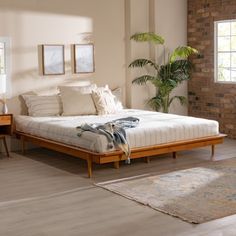 a bed sitting in a bedroom next to a wooden dresser and mirror on top of a hard wood floor