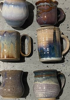 four different types of coffee mugs sitting next to each other on a counter top