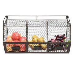 three bins filled with fruits and vegetables on top of a white background in front of a wire fence