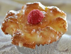 a close up of a muffin with a raspberry on top