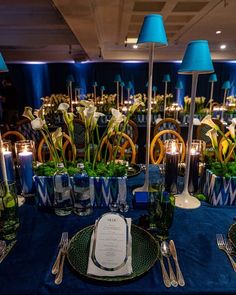 a table set with plates, silverware and blue linens for a formal dinner