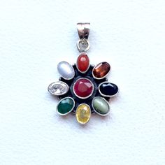 Genuine 925 Sterling Silver Navratan Pandent  Gemstone - Ruby , Emerald , Blue Sapphire, Yellow Sapphire, Hessonite, Cats Eye, Coral, Pearl, Cubic Zircona.  Stones setted - 9 pieces QTY - 1 piece in this listing. The navratna or nine gems influencing the nine planets are:  Ruby  =  Sun ,  Pearl = Moon, Red Coral = Mars, Emerald = Mercury,  Yellow Sapphire = Jupiter, zircon = Venus, Blue Sapphire = Saturn,  Hessonite = Rahu , Cat''s Eye = Ketu . Multicolor Stone Round Pendant Jewelry, Traditional Multi-stone Gemstones As Gift, Traditional Multi-stone Gemstones For Gifts, Multicolor Round Pendant Jewelry With Stones, Spiritual Silver Gemstone With Oval Pendant, Spiritual Silver Oval Pendant Gemstone, Traditional Natural Gemstones As Gifts, Spiritual 925 Sterling Silver Gemstones, Multicolor Gemstone Round Pendant Jewelry