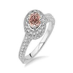 a white gold ring with an oval pink diamond in the center and pave diamonds around it