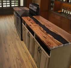 a kitchen counter made out of wood and metal with an oven in the center island