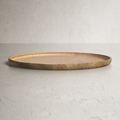 a wooden plate sitting on top of a white table