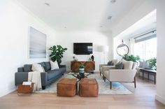 a living room filled with furniture and a flat screen tv mounted to the side of a wall