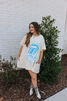 Elevate your wardrobe with our Cream Rolling Stones T-Shirt Dress! Made from high-quality materials, this dress features a classic Rolling Stones graphic that will make a statement wherever you go. Comfortable and stylish, this dress is perfect for any occasion. Embrace your love for music and dress to impress! Model wearing a small. Cotton Graphic Print T-shirt Dress With Short Sleeves, Cotton Graphic T-shirt Dress With Short Sleeves, Oversized Cotton T-shirt Dress With Graphic Print, Cotton Graphic Print Short Sleeve T-shirt Dress, Graphic Tee T-shirt Dress With Crew Neck, Graphic Print T-shirt Dress With Crew Neck, Graphic Print Crew Neck T-shirt Dress, Cotton T-shirt Dress With Graphic Print, Relaxed Fit, White Graphic Print T-shirt Dress With Crew Neck