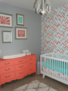 a baby's room with an orange dresser and crib