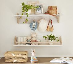 a shelf filled with stuffed animals on top of a wooden floor next to a basket