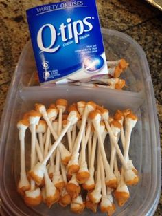 a plastic container filled with marshmallows next to a package of q tips