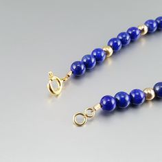 Classic bracelet with blue Lapis Lazuli polished beads and 14K gold plated beads and clasp. Unique gift for her, girlfriend, mom, sister, friendship stone gift, September and December birthstone, 9 year anniversary. The stones are arranged symmetrically with the precious metal parts. The stones are strung on stainless steel and finished with a Sterling silver 3 times 14K gold plated clasp. All our stones are natural stones and our jewelry handmade, slight differences in color and shape may occur Gold Bracelets With Lapis Lazuli And Natural Stones, Gift Lapis Lazuli Beaded Bracelets With Polished Beads, Gold Lapis Lazuli Beaded Bracelets With Round Beads, Gold Lapis Lazuli Bracelet With Gemstone, Gold Lapis Lazuli Gemstone Bracelet, Hand-strung Gold Lapis Lazuli Bracelets, Gold Lapis Lazuli Jewelry With Polished Beads, 14k Gold Beaded Bracelets With Polished Beads As Gift, Lapis Lazuli Round Beads Jewelry As Gift