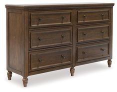 a wooden dresser with many drawers and knobs on the top, against a white background