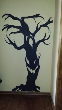 a wall with a tree painted on it and a door way leading to another room