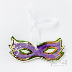 Made for you holiday or Mardi Gras tree! Ceramic carnival mask ornament handmade and hand painted in Louisiana with metallic 22K gold accents. Comes with a white hanging ribbon.  Measure 4.5" x 2" tall.  This listing is for one ornament. Venetian Masks For Mardi Gras Gift, Venetian Masks For Mardi Gras, Gold Carnival Masks As Gift, Mardi Gras Tree, Purple Mask, Carnival Mask, Carnival Masks, Handmade Ornaments, 22k Gold