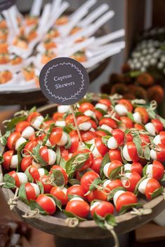 tomatoes and mozzarella are arranged in a basket for sale at a farmers market