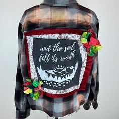 a flannel shirt with an image of a mountain and the words and the sun fell its worth on it