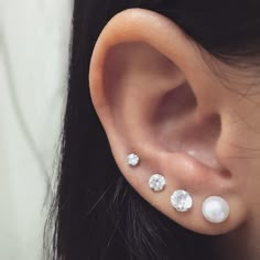 a woman's ear with three different types of piercings