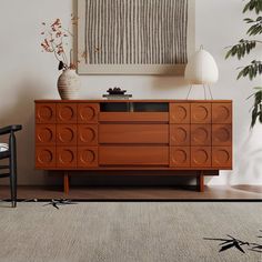 a living room with a large wooden cabinet and plant on the floor next to it