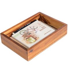 a wooden box with a notepad and pen in it