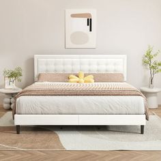 a white bed sitting in a bedroom on top of a hard wood floor next to a rug