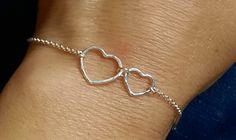 This fabulous bracelet features a hammered sterling silver heart charms on a delicate sterling silver rolo chain. Finished with a spring bolt clasp.  The bracelet will include a short (1inch) extender to ensure a better fit. * Heart charms measures: smaller 10 / larger 15 mm * It will arrive in a gift box Adjustable Sterling Silver Bracelet For Anniversary, Dainty Sterling Silver Charm Bracelet With Heart Charm, Sterling Silver Double Heart Bracelets, Minimalist Sterling Silver Heart Bracelet For Anniversary, Delicate Silver Bracelets With Heart Charm, Delicate Sterling Silver Heart Bracelets, Delicate Sterling Silver Heart Bracelet, Delicate Heart Shaped Sterling Silver Bracelet, Silver Heart Bracelets For Anniversary Gift