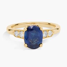 The rich warmth of the 14k yellow gold gorgeously contrasts and complements the deep blue oval-cut sapphire at the heart of this ring. A duo of accent diamonds lend luxurious sparkle on either side of the dramatic centre stone. Side Stone Ring, Blue Sapphire Wedding Ring, Dope Jewelry, Something Blue, Precious Gemstones, The Deep, Stone Ring, Oval Cut, Deep Blue