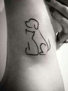 a dog and cat tattoo on the side of a woman's stomach, with words written