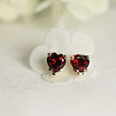 "These minimalist and modern heart garnet stud earrings are a beautiful choice for anyone who loves elegant and understated jewelry. The 14k gold prong setting provides a secure and luxurious setting for the red gemstone, while the heart shape adds a touch of sweetness to the design. As a birthstone for January, garnet is said to represent love, loyalty, and friendship, making these earrings a thoughtful gift for anyone born in that month. SOLD AS PAIR. Available white gold or yellow gold from d Fine Jewelry Heart Earrings For Wedding On Valentine's Day, Elegant Heart Cut Earrings For Gift, Elegant Heart Shaped Earrings For Anniversary, Elegant Heart-shaped Earrings For Anniversary, Elegant Earrings For Valentine's Day Anniversary Gift, Elegant Heart Earrings For Valentine's Day Anniversary, Elegant Earrings For Anniversary, Valentine's Day Gift, Elegant Formal Heart Gemstone Earrings, Elegant Gemstone Heart Earrings For Formal Occasions