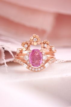 Oval vivid pink sapphire & diamonds ring in a bridal ring set with a diamond flowers band and a curve wedding ring Exquisite Pink Diamond Ring With Rose Cut, Pink Sapphire Ring With Rose Cut Diamonds, Round Pink Sapphire Ring With Rose Cut Diamonds, Gold Pink Sapphire Ring For Wedding, Wedding Gold Pink Sapphire Ring, Wedding Yellow Gold Pink Sapphire Ring, Wedding Pink Sapphire Ring In Yellow Gold, Anniversary Rings With Rose Cut Pink Sapphire, Anniversary Pink Sapphire Ring With Rose Cut Diamonds