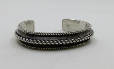 Solid, sterling silver bangle cuff, twisted wire overlay. Vintage Navajo, stunning piece by artisan Tom Hawk. Dimensions of bangle: Width 13mm (0.55") Length of metal 6" approx Internal dimensions 58mm x 45mm (2.5" x 1.85") Gap 1.1" (slightly adjustable)  Weight 43.6 grams Would suit a smaller 6 - 7" wrist Please check out my other designs and vintage pieces here: https://www.etsy.com/uk/shop/YouGotTheSilverUK  Click on customise for any custom queries or bespoke pieces. Artisan Silver Bangle Hand Wrapped, Artisan Hand-wrapped Silver Bangle, Artisan Silver Hand Wrapped Cuff Bracelet, Artisan Hand Wrapped Silver Cuff Bracelet, Artisan Hand-wrapped Silver Cuff Bracelet, Artisan Oxidized Finish Cuff Bangle Bracelet, Artisan Oxidized Bangle Cuff Bracelet, Sterling Silver Bangle, Twisted Wire