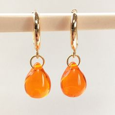 Stunning bright orange Czech glass is featured in these classic drop earrings. with quality gold huggie hoop fittings. The summery colour is simply gorgeous and stands out when you wear them. The light shines through these  transparent glossy drops.   Want this style in other colours? - https://etsy.me/3Dylcpd  - just ask Other orange earrings in this shop - https://rb.gy/kmr026 The teardrop is a popular shape and so is perfect for gifting to ladies you know-  sister, friend, wife, as well as fo Gold Teardrop Earrings, Huggie Earrings Gold, Glass Drop Earrings, Orange Earrings, Hoop Earrings Gold, Classic Earrings, Earrings Dainty, Classic Jewelry, Huggie Hoop Earrings