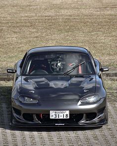 a black sports car parked in front of a wooden fence