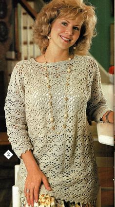 a woman standing in front of a kitchen counter holding a purse and smiling at the camera