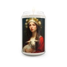 a candle with a painting of a woman holding a lamb