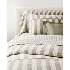 a bed with striped sheets and pillows on it